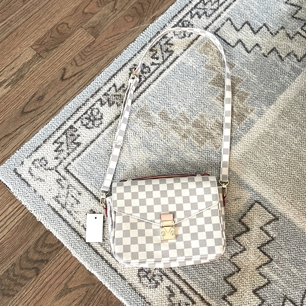 Never used! Very cute Crossbody with an optional handle. Lightweight.